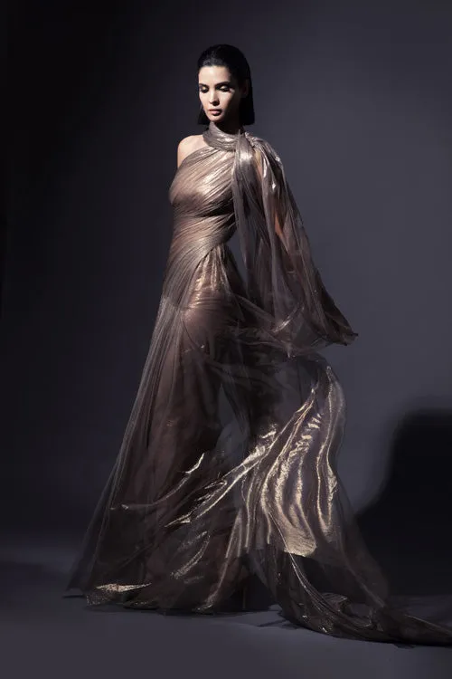 Exquisitely draped asymmetrical halter gown with caped open sleeve in fairy-spun bronze foiled silk tulle