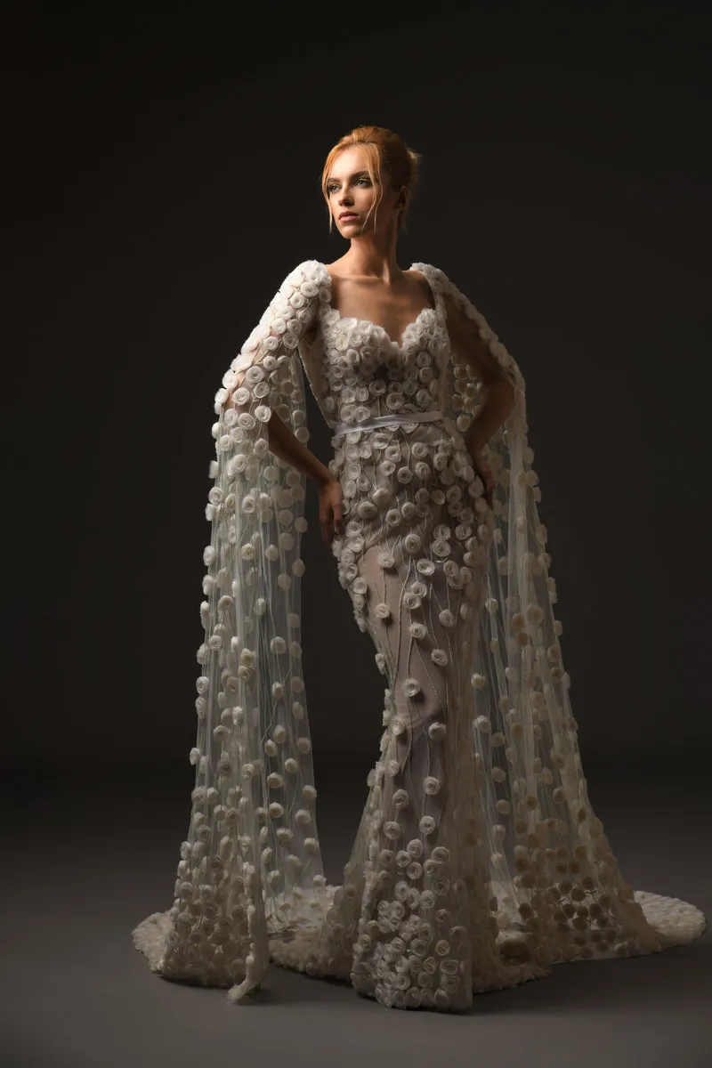 Silk tulle bridal gown embellished with hand-crafted silk organza roses featuring a sleeved cape